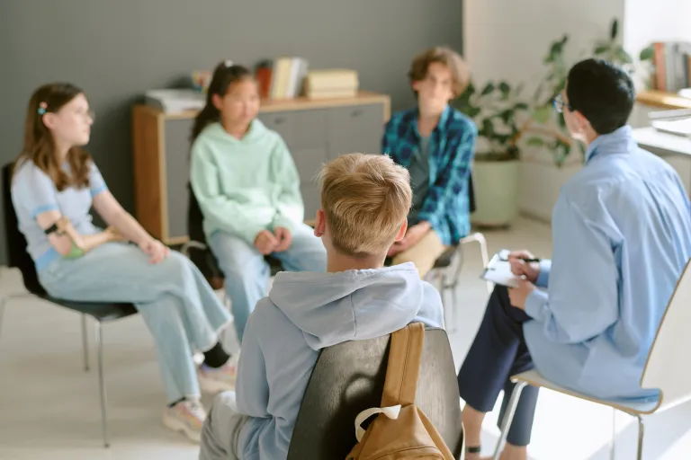 Teenagers in a skills group session with a counselor