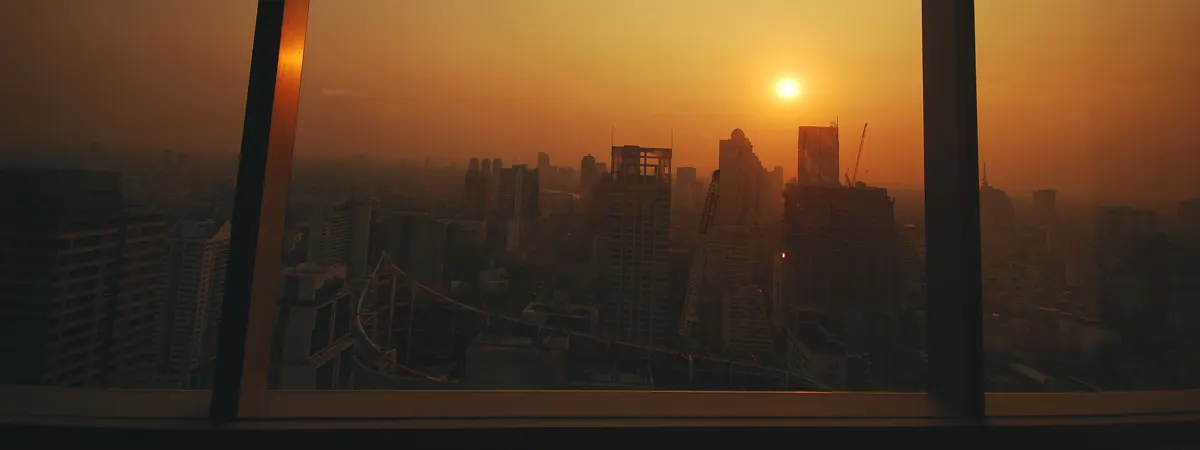 Golden sunrise over a city skyline seen from an executive office window