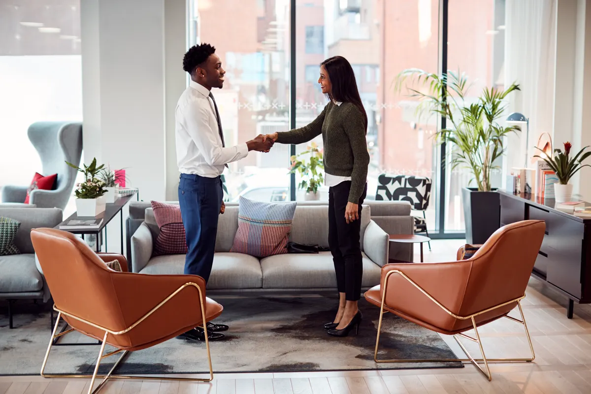 Two professionals in conversation in a modern Northwest Arkansas office lounge