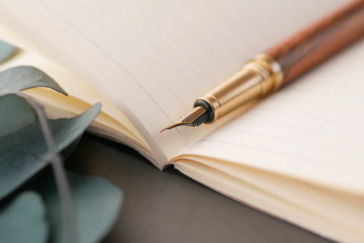 Fountain pen resting on an open linen notebook in morning light